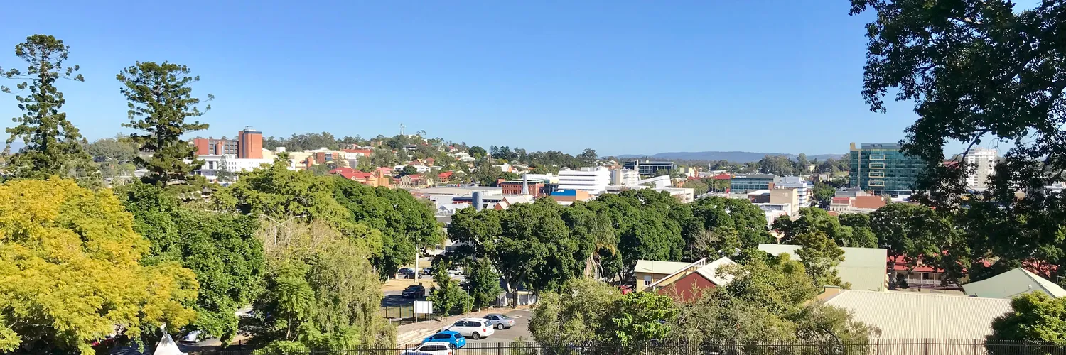 Ipswich city centre and tree-lined streets seen from Cunninghams Knoll under a clear blue sky